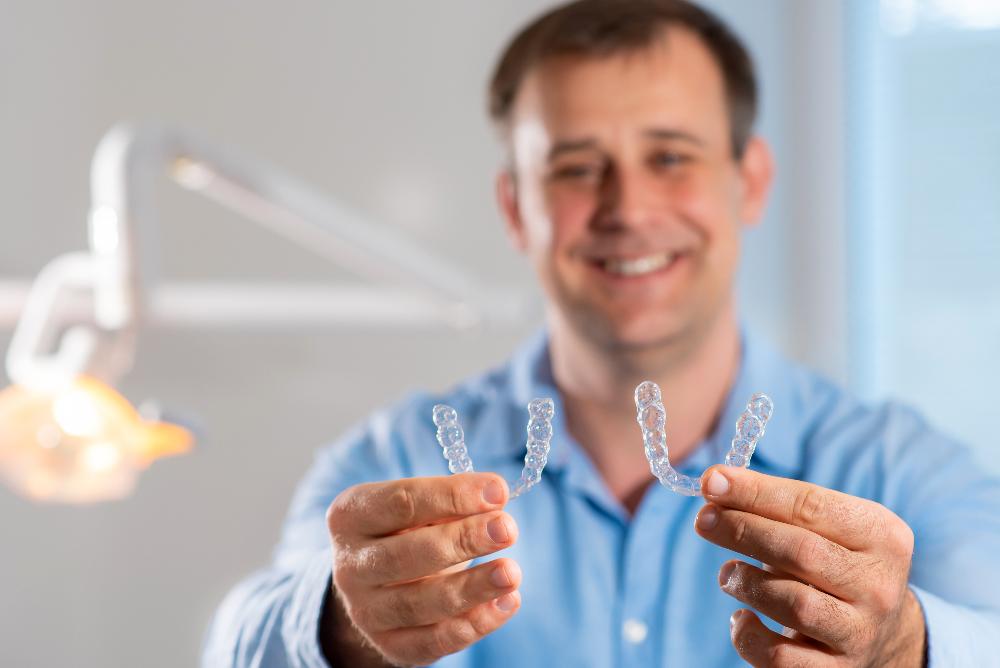 A man holding two Invisalign trays