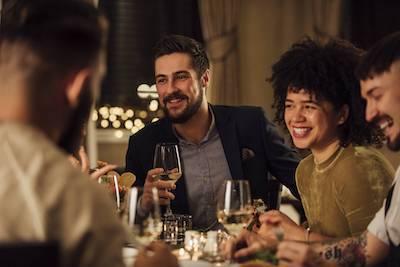 A group laughing over dinner conversation