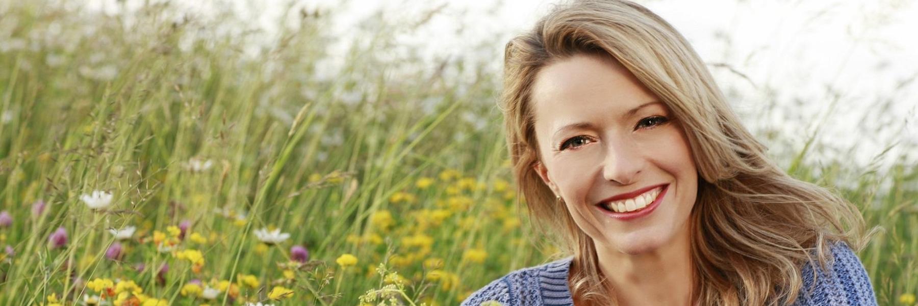 Smiling woman in a field | dentist St. Augustine, FL