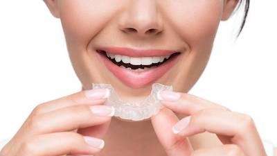 A woman putting in her Invisalign tray