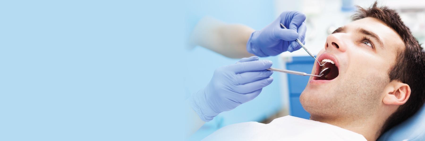 Man sitting in dental chair getting periodontal exam